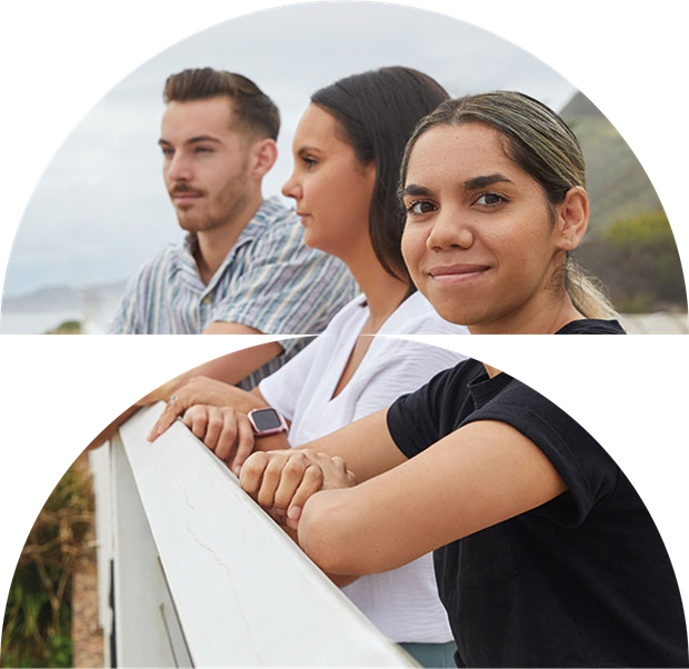 Young indigenous woman looking straight ahead with two other students tin the background, holding onto a railing
