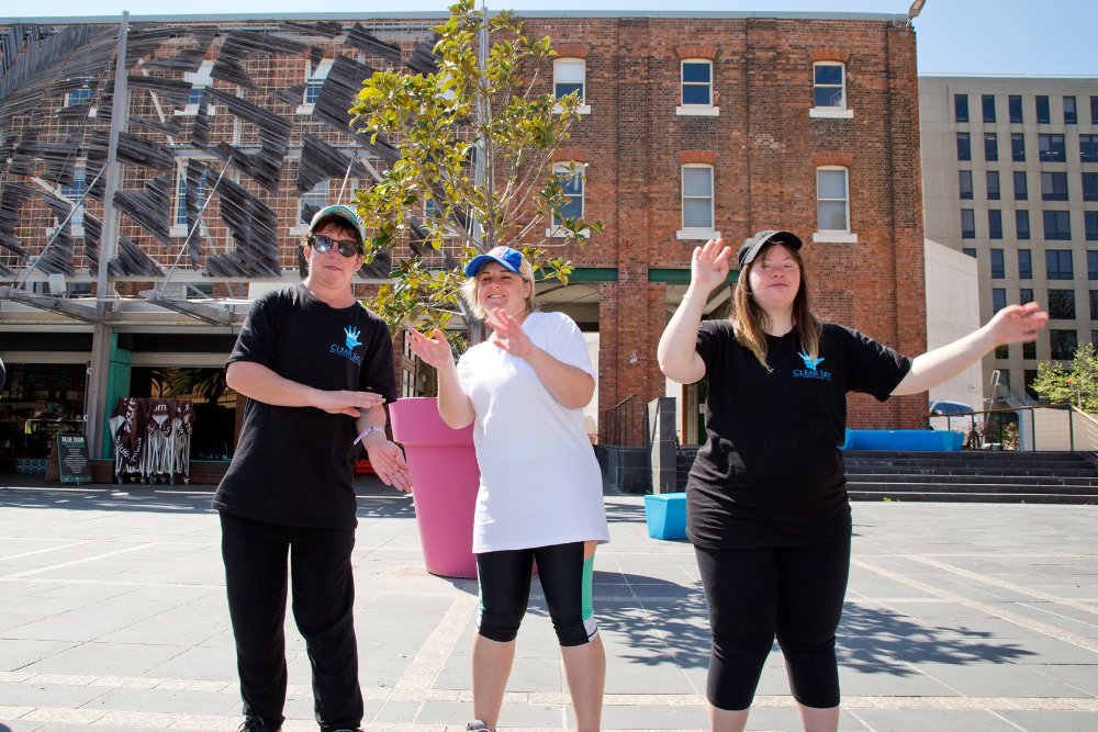 Three women dancing at a disability inclusion festival