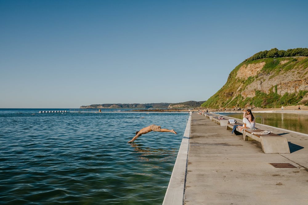 A lady diving into the water at Merewether Ocean Baths