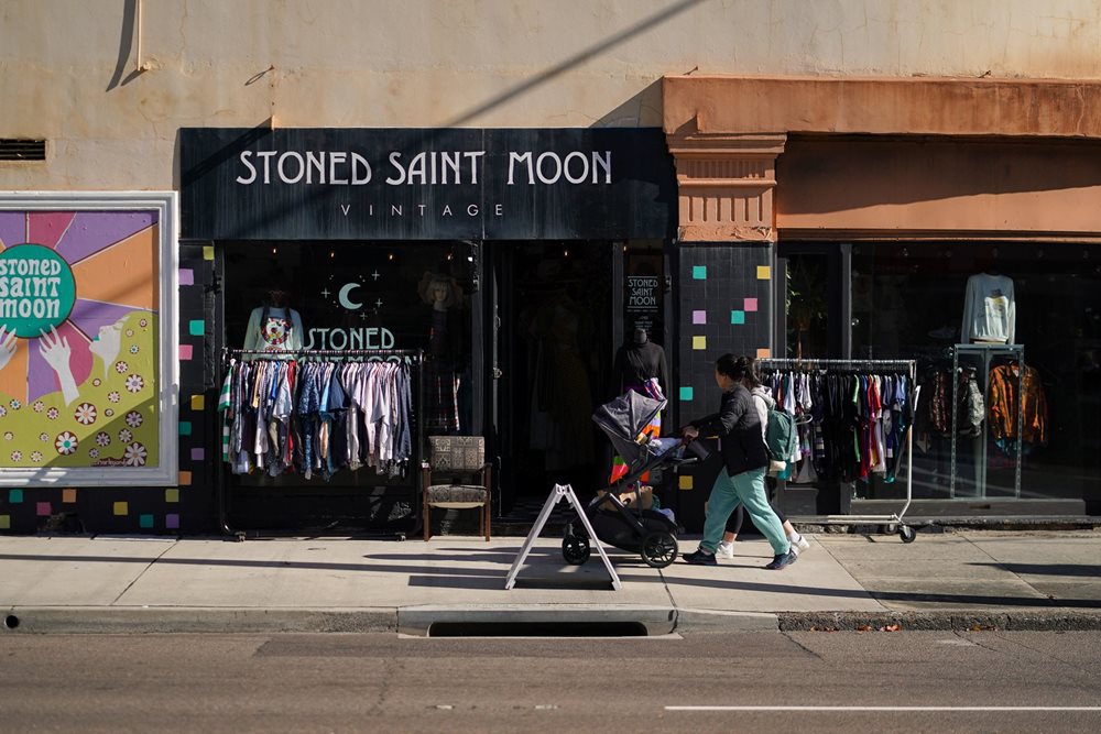 Person walking past Stoned Saint Moon vintage shop in Hamilton