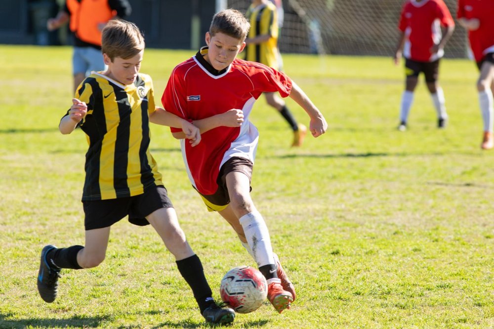 Two young kids playing soccer