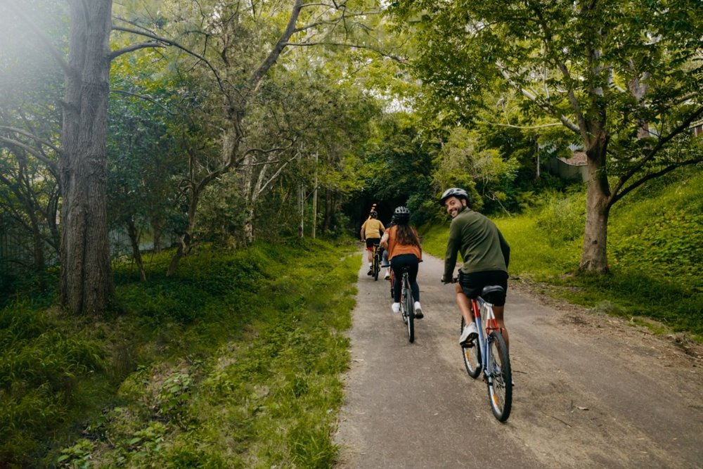 three cyclists riding on a bush trail in newcastle