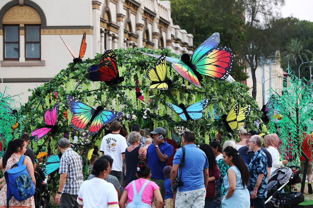People crowding at a butterfly display at a New Years event