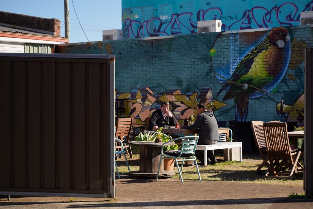 Hidden cafe courtyard in front of street art in Mayfield