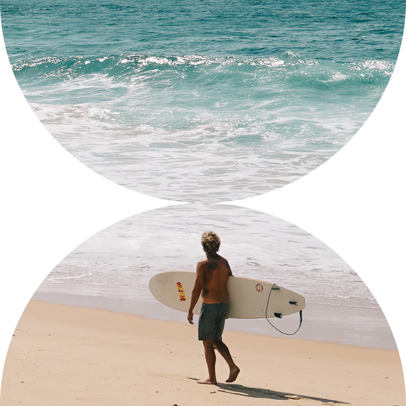 Surfer walking along the beach