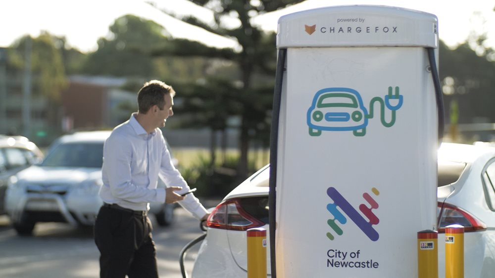 A man charging his electric car at a City of Newcastle charging station