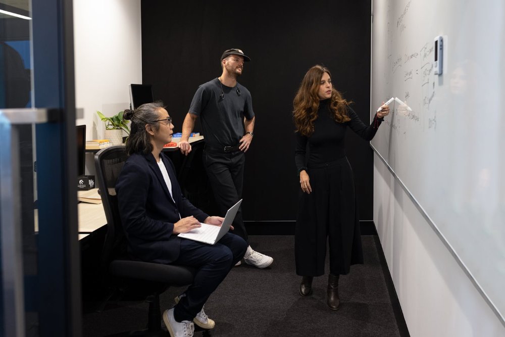 Three people working in a small office at the Landing Pad