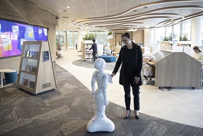 A woman interacts with a robot at Newcastle Digital Library