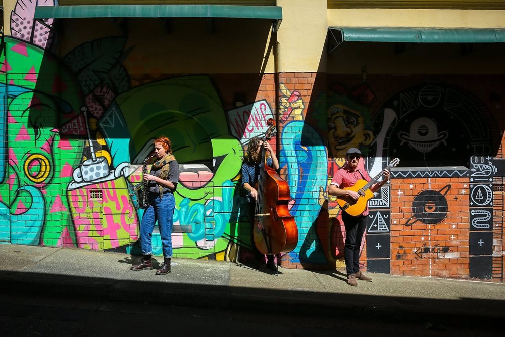 Music buskers playing in front of street art