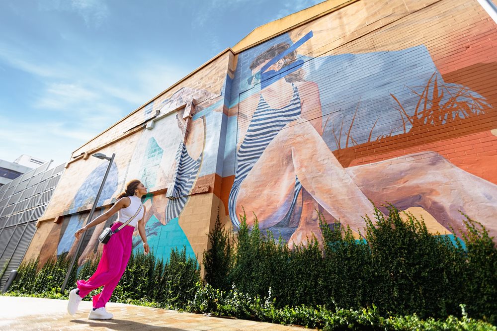 A lady walking and admiring street art in Newcastle